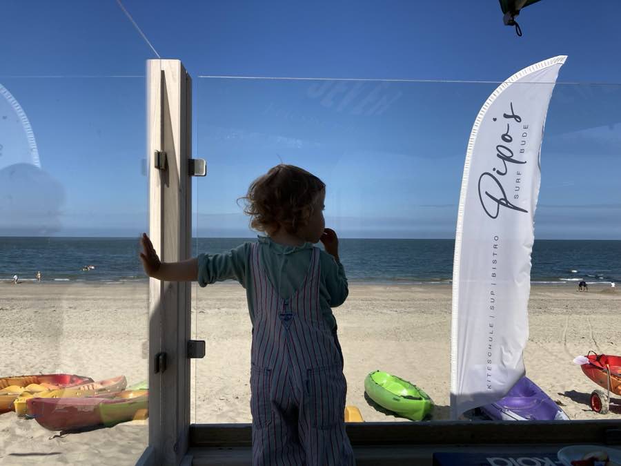 Kind auf der Terrasse von Pipo’s Surfbude mit Blick aufs Meer